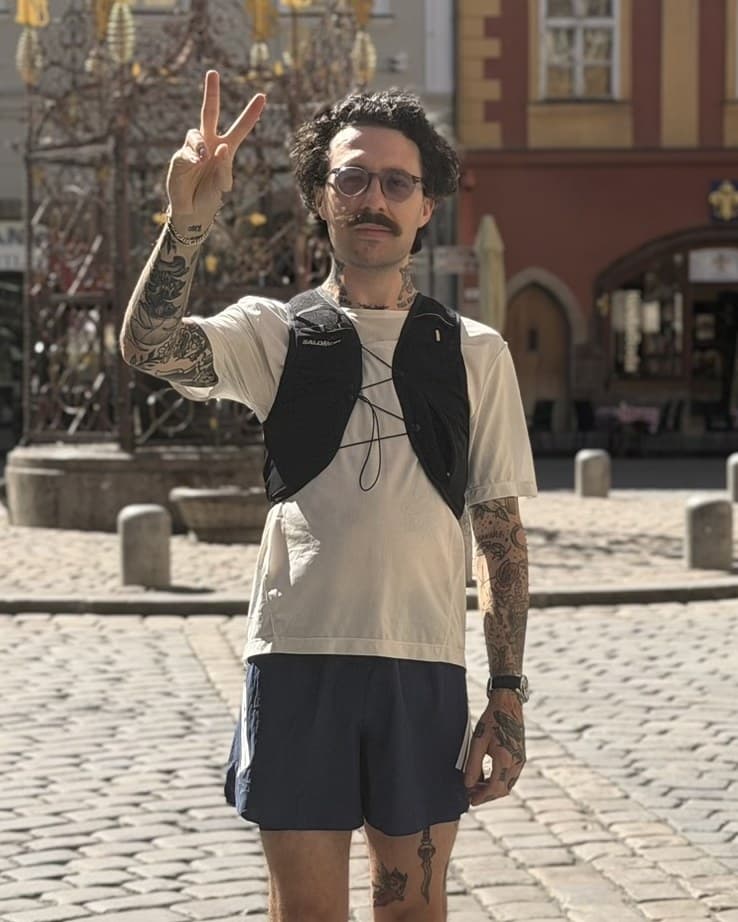 Curtis giving a peace sign in a sunny town square