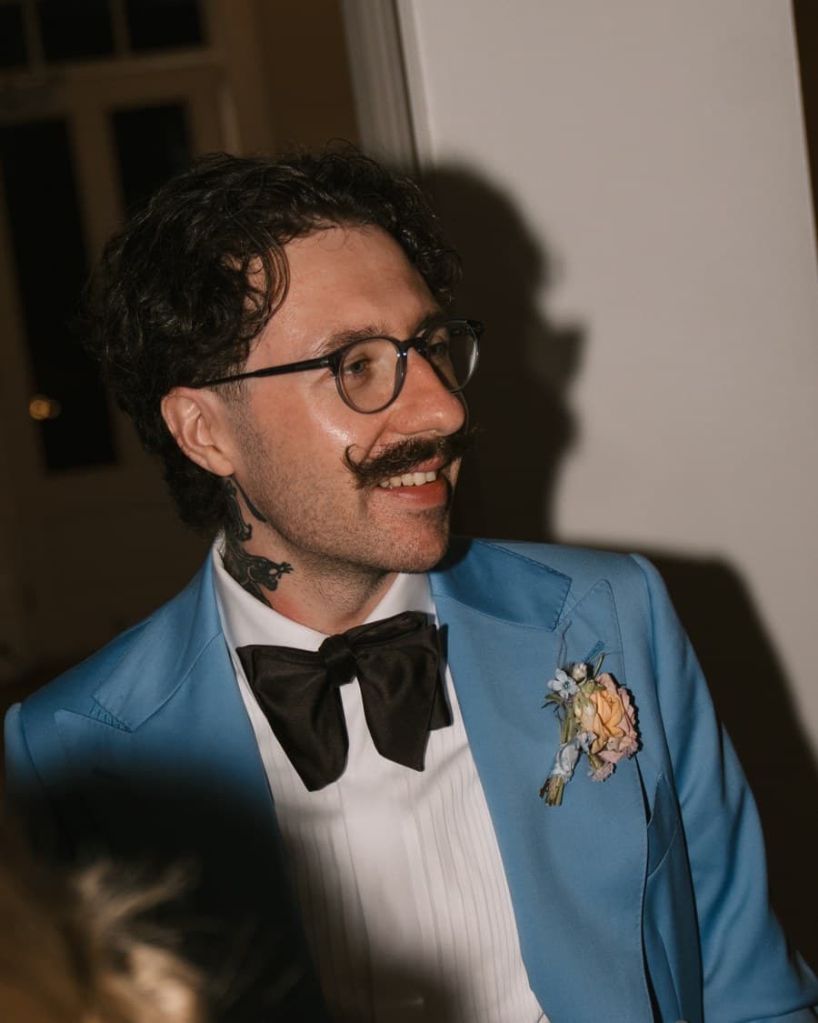 Curtis, smiling, in a blue jacket and bow tie